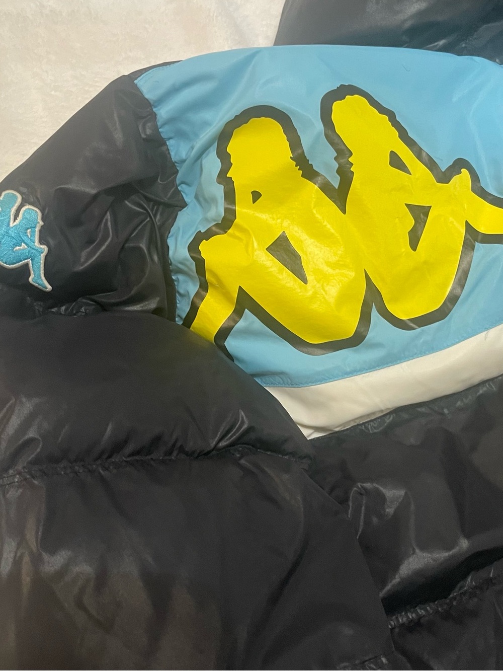 Kappa Black Puffer Jacket with Sky Blue Panel and Yellow Logo FLAWS